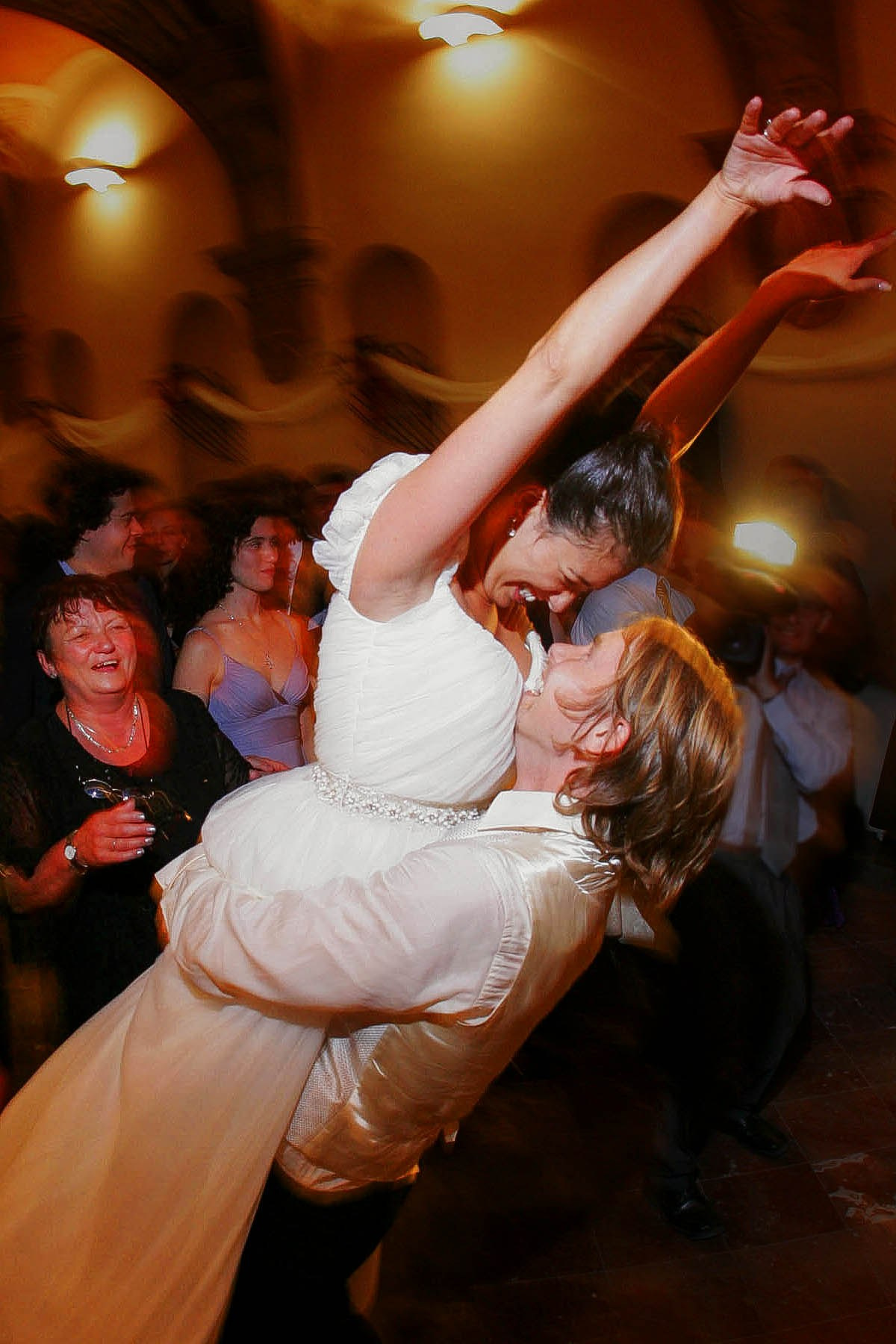 A Czech groom catches his beautiful Brazilian wife as she jumps into his arms during their wedding day celebrations at the Troja Palace in Prague.