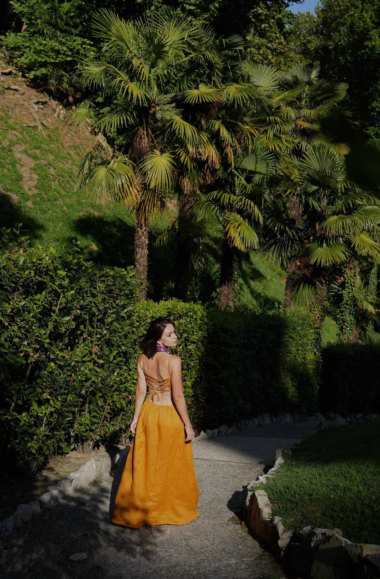 Woman walking through a garden at Lake Como