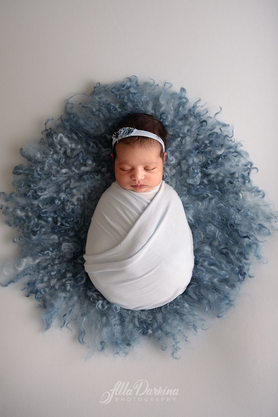 Infant girl with flower crown in pastel blue wrap newborn session in Sydney.