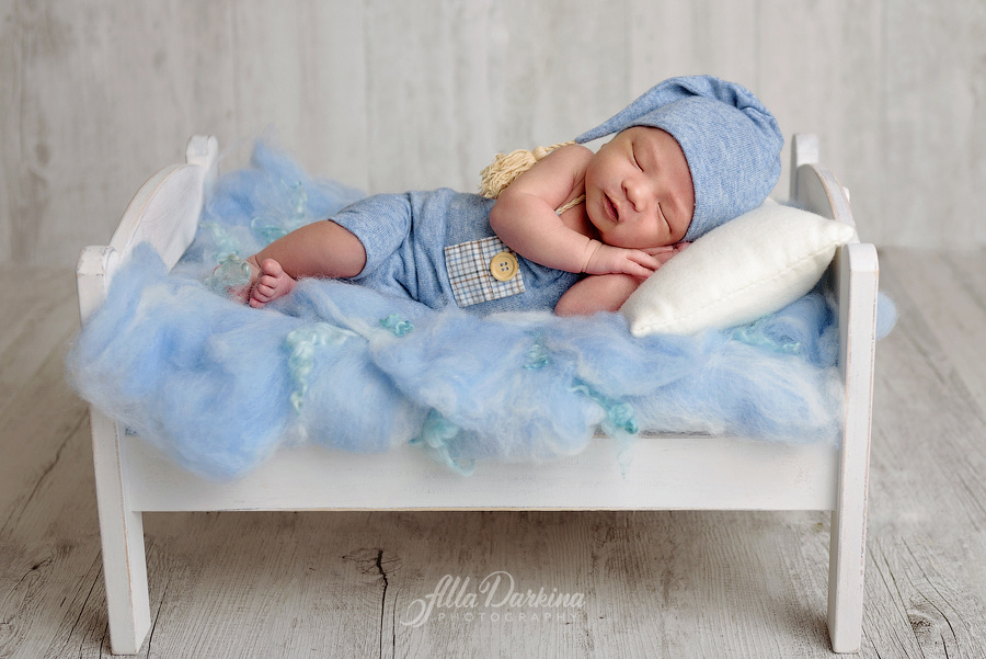 Sleeping newborn baby on fluffy pastel blue blanket.