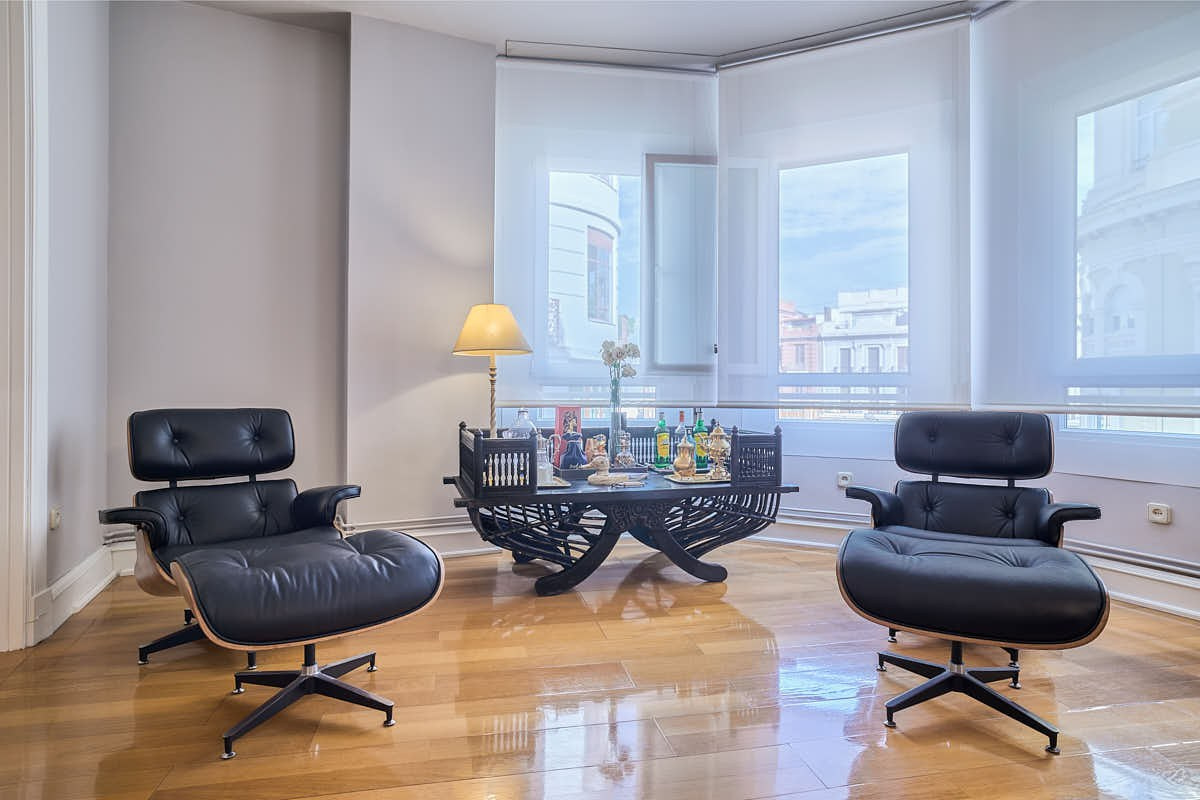 Salón luminoso con sillones de diseño y grandes ventanales en Valencia