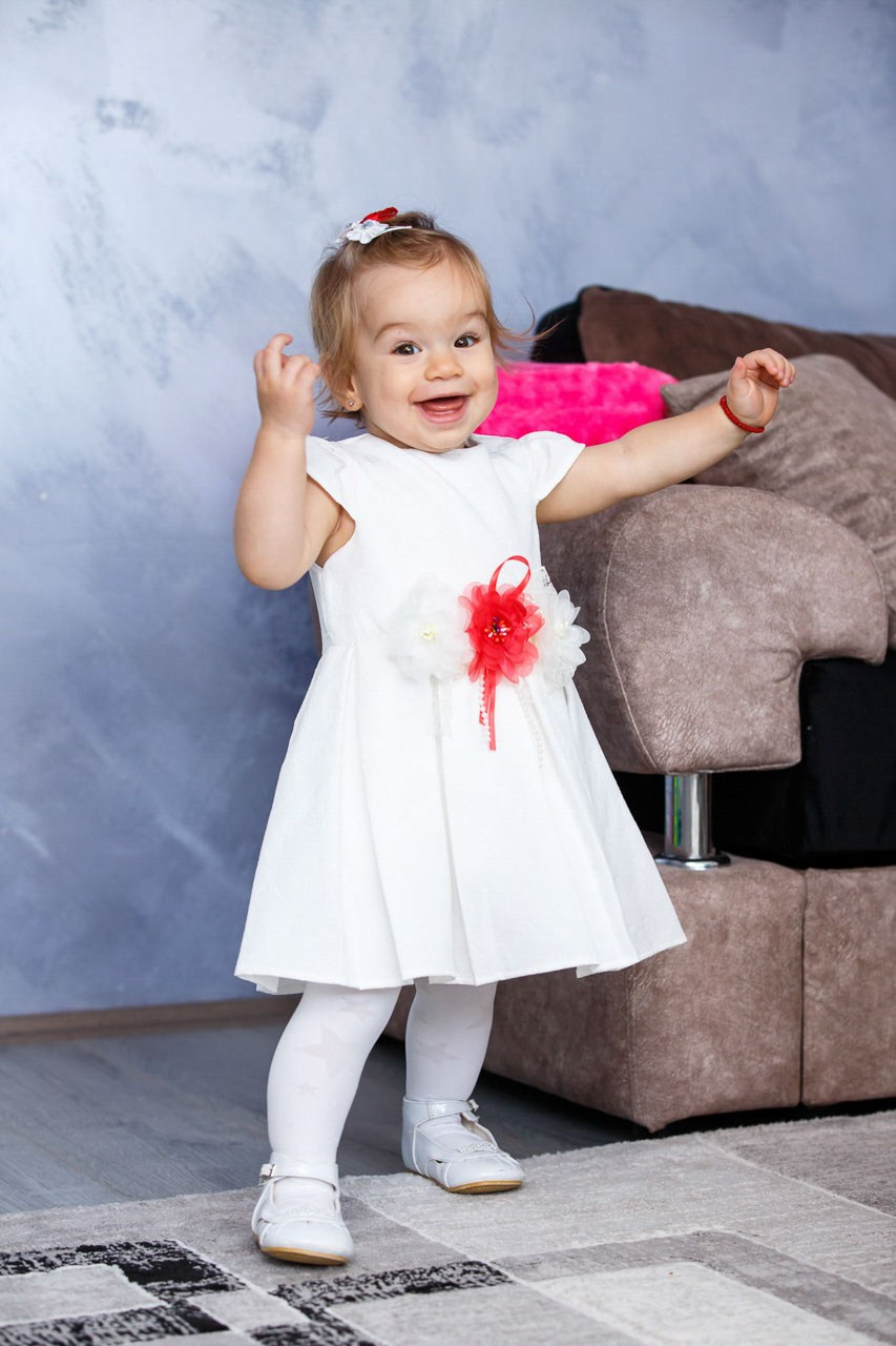 Dete u svečanoj odeći nakon obreda krštenja.