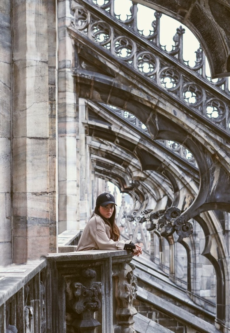Ragazza sul balcone sul tetto del Duomo, godendosi la vista sulla città.