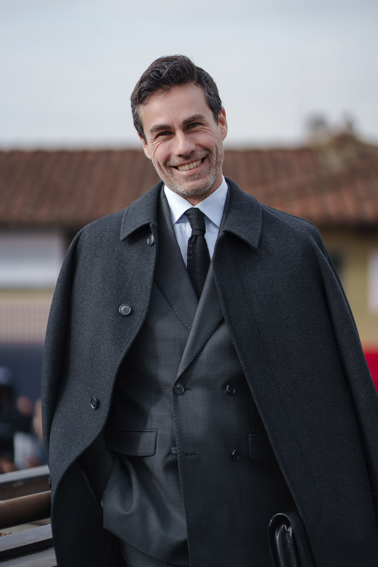 Smiling man in elegant dark suit at Pitti Uomo 109 Florence
