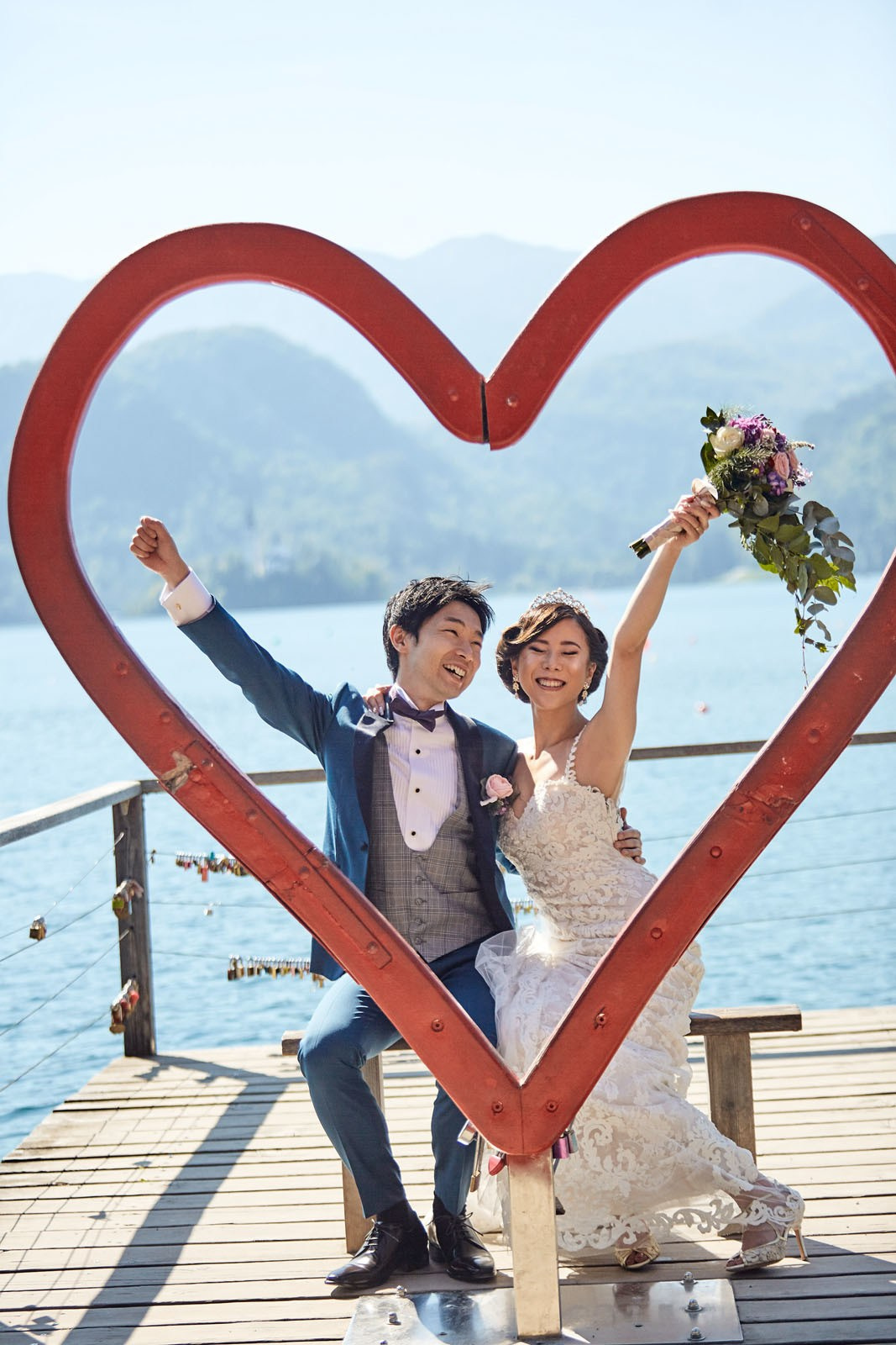 Stylish couple posing with Heart of Lake Bled sculpture.