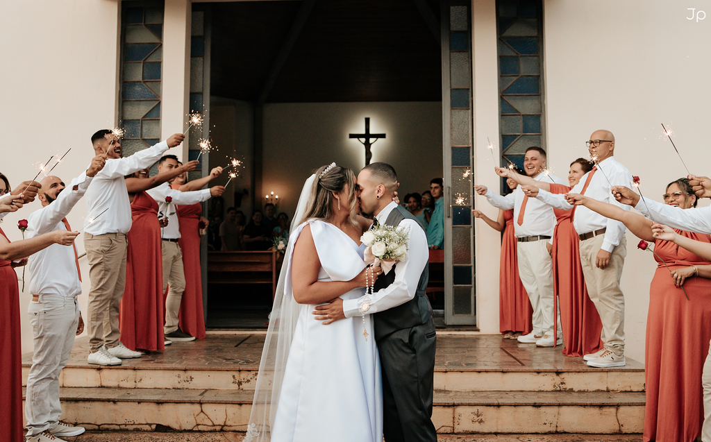 Fotógrafo em Bariri tira fotos dos noivos no centro e padrinhos alinhados.
