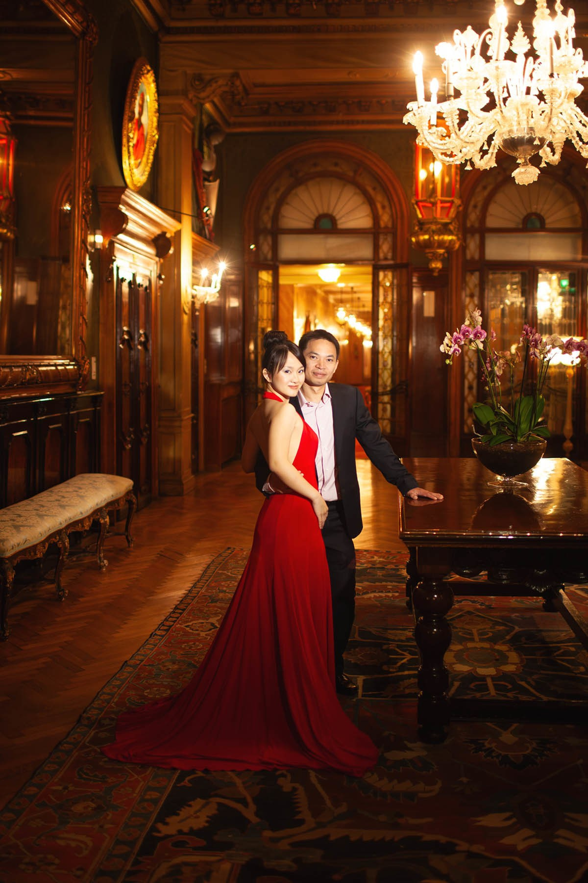 Smiling Thai couple embracing amid opulent interiors of Hotel Danieli in Venice.