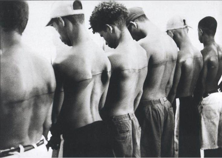 Сантьяго Сьерра, 250-сантиметровая линия, татуированная на шести людях (1999, Гавана). Кадр из видеодокументации акции, где участникам заплатили по 30 долларов.»