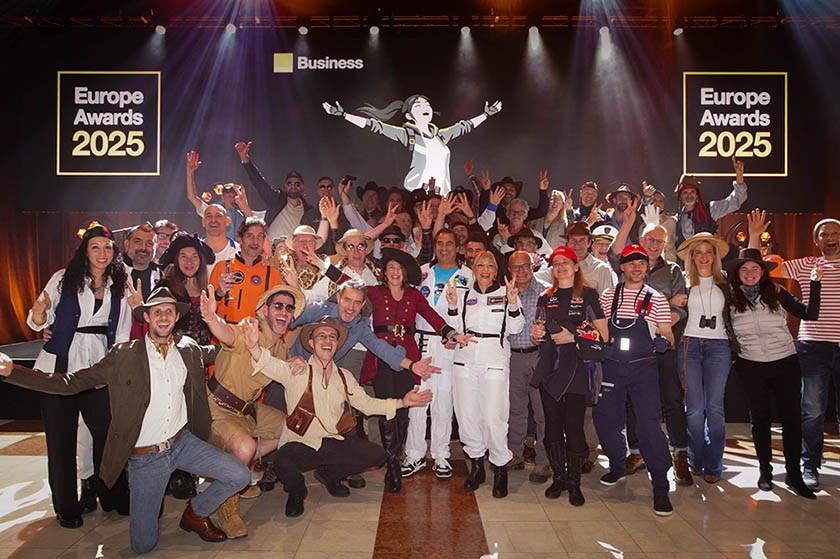 Corporate event photography of a large group of costumed people on stage.
