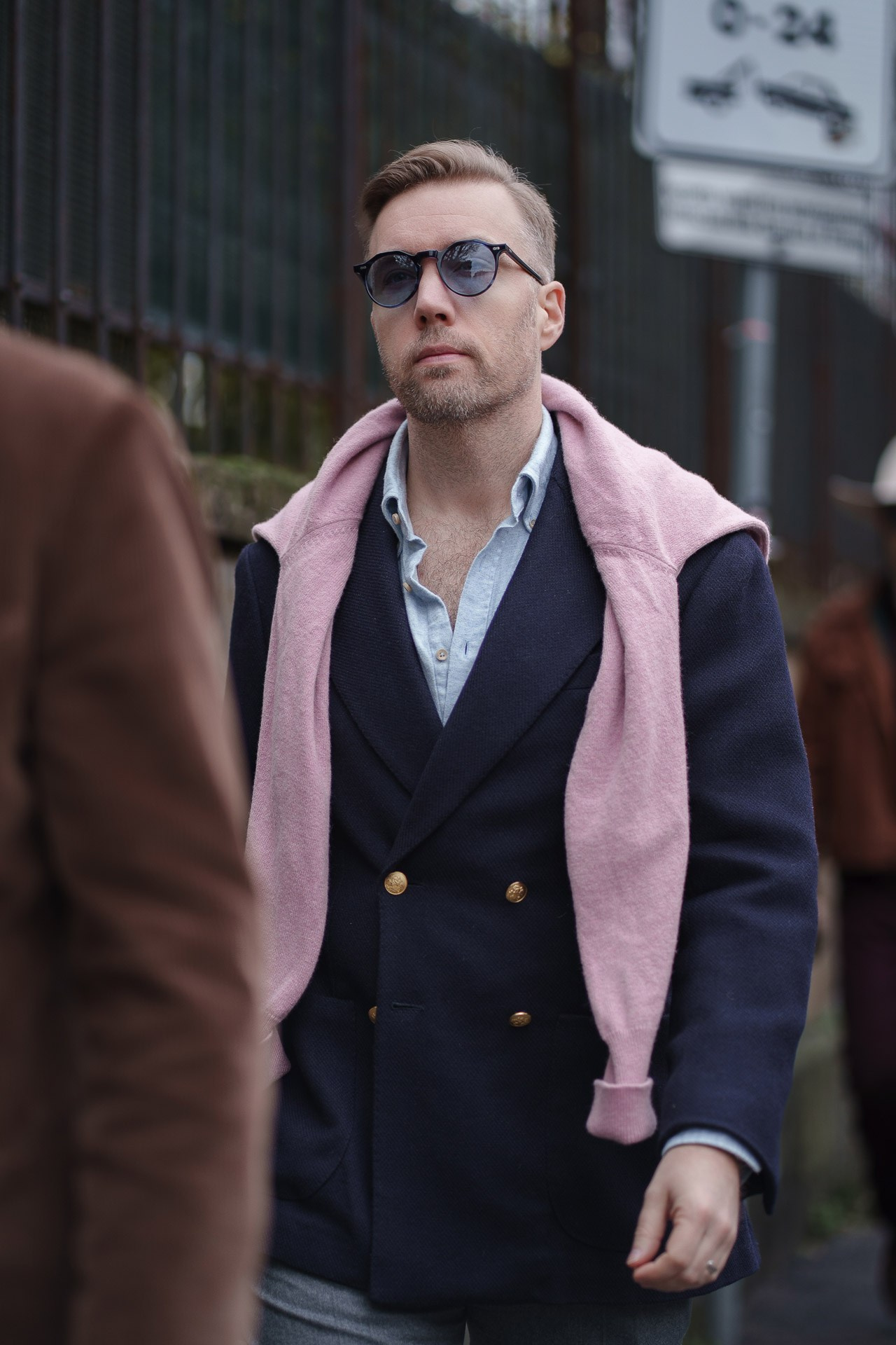 Man in navy double breasted blazer with pink scarf at Pitti Uomo Florence street style