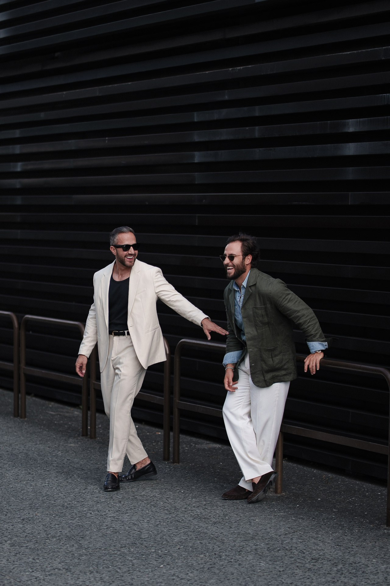 Pitti Uomo 110 street style scene, two guests in white and green tailored looks walking in Florence