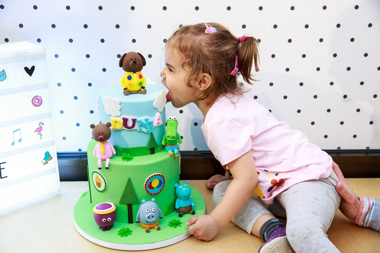 Slavljenica proba slatku zelenu tortu na proslavi rođendana.