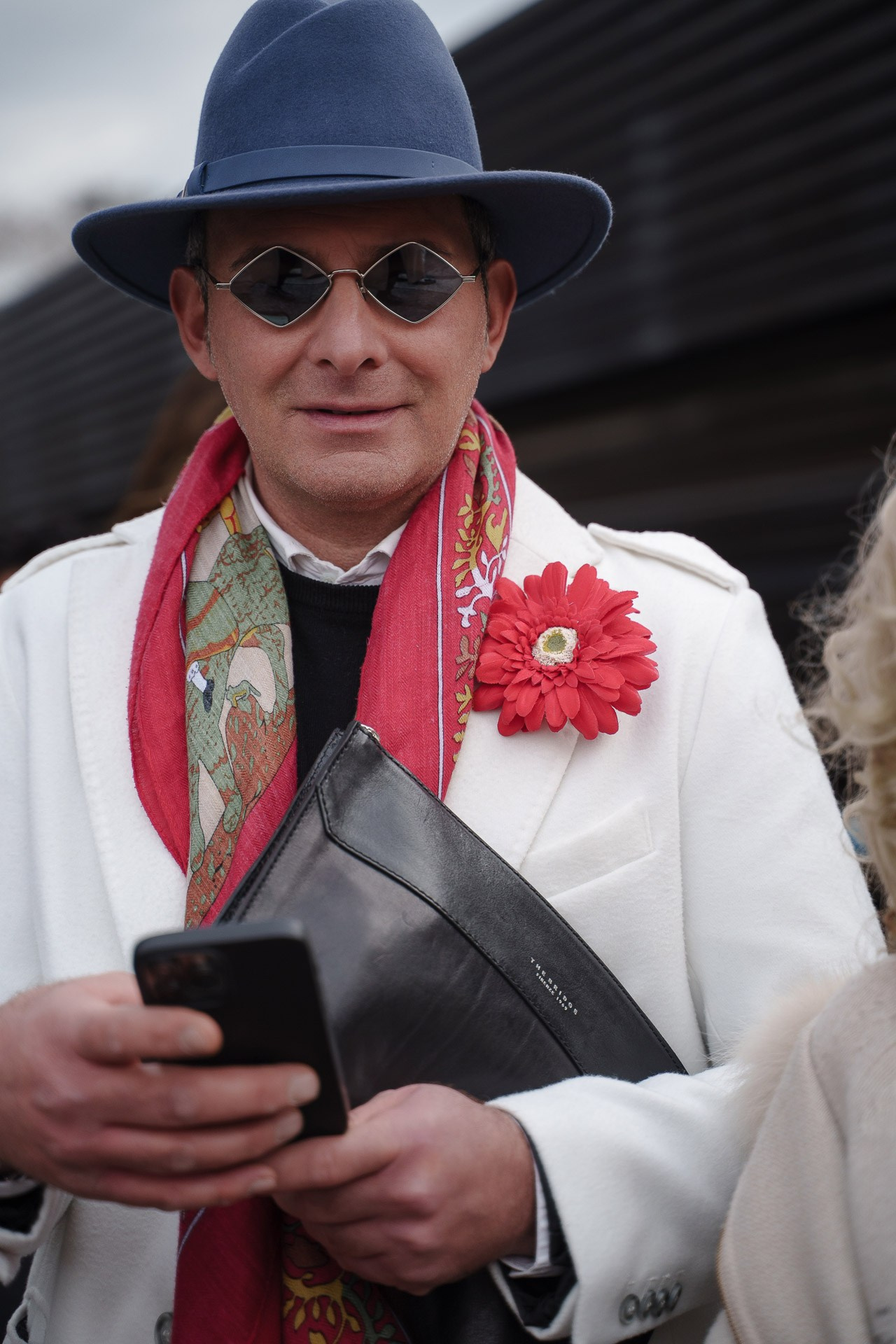 Man in white coat and hat with colorful scarf at Pitti Uomo Florence