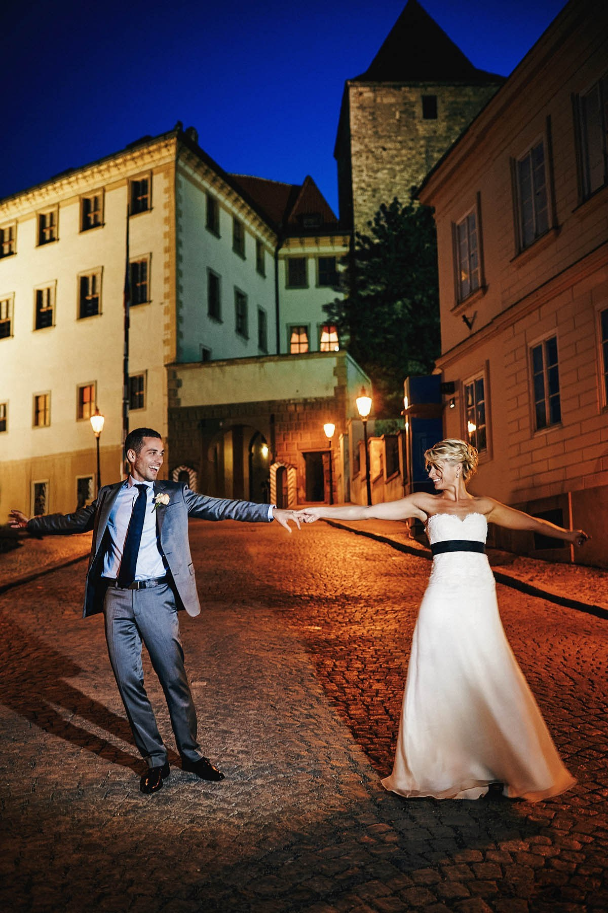 Couple dancing at night in front of Prague Castle entrance