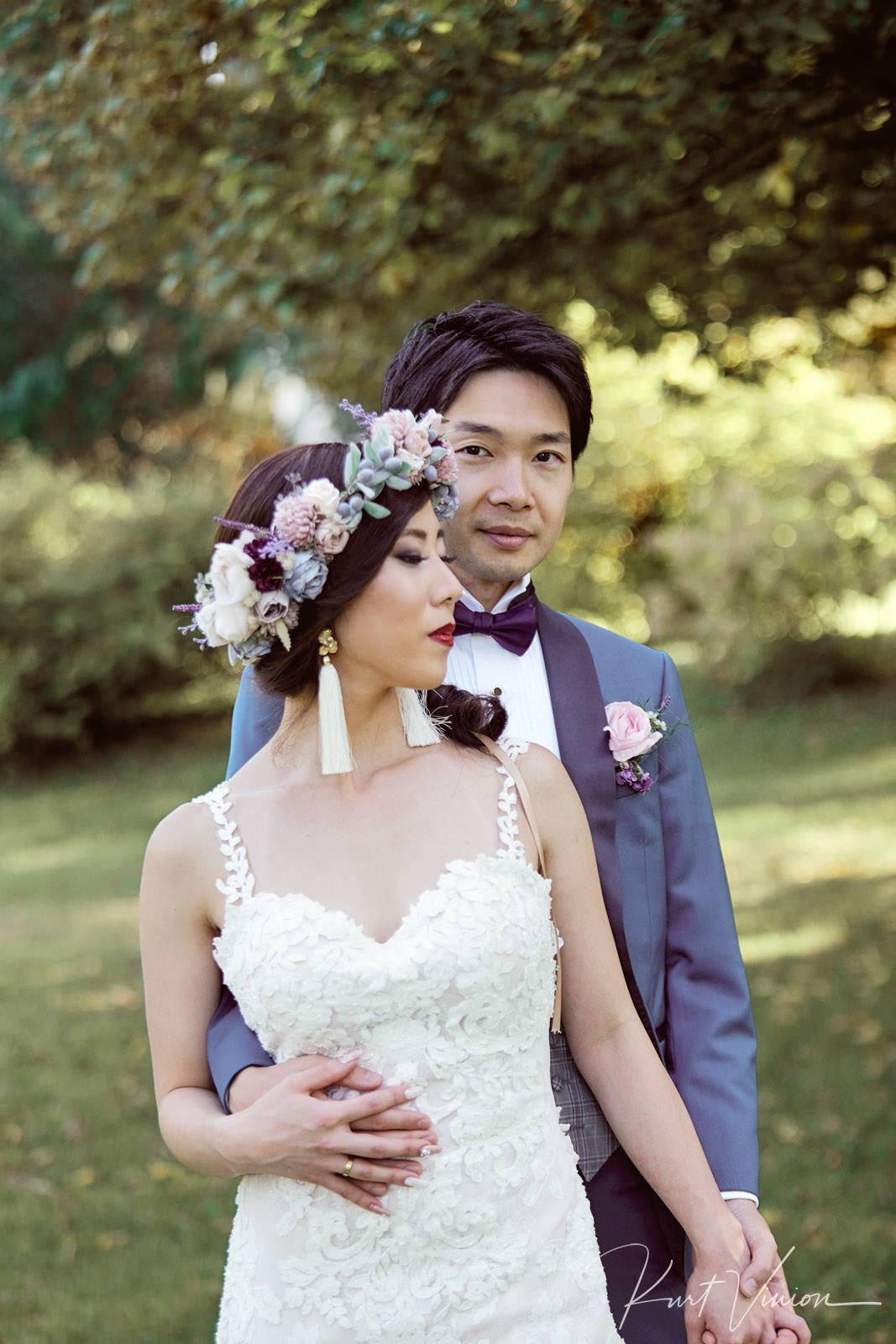 Newlyweds standing embracing softly Vila Bled terrace twilight.