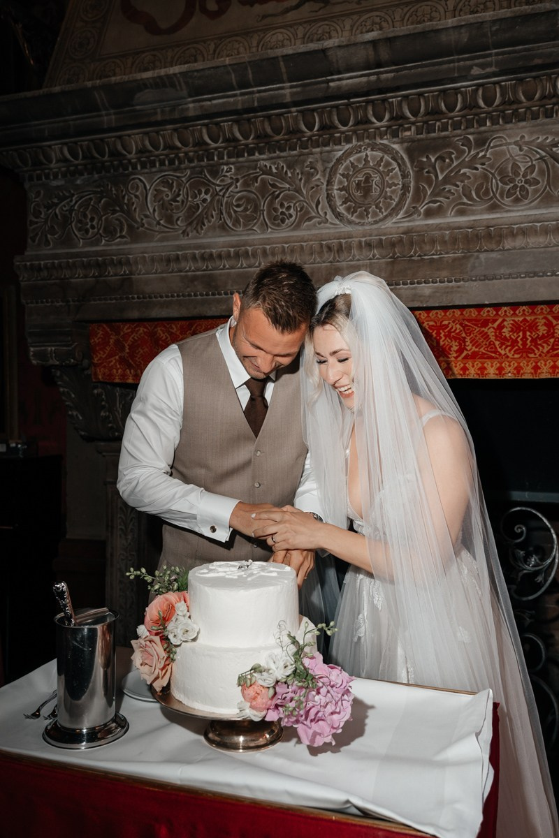 bride and groom cut the cake and smiling