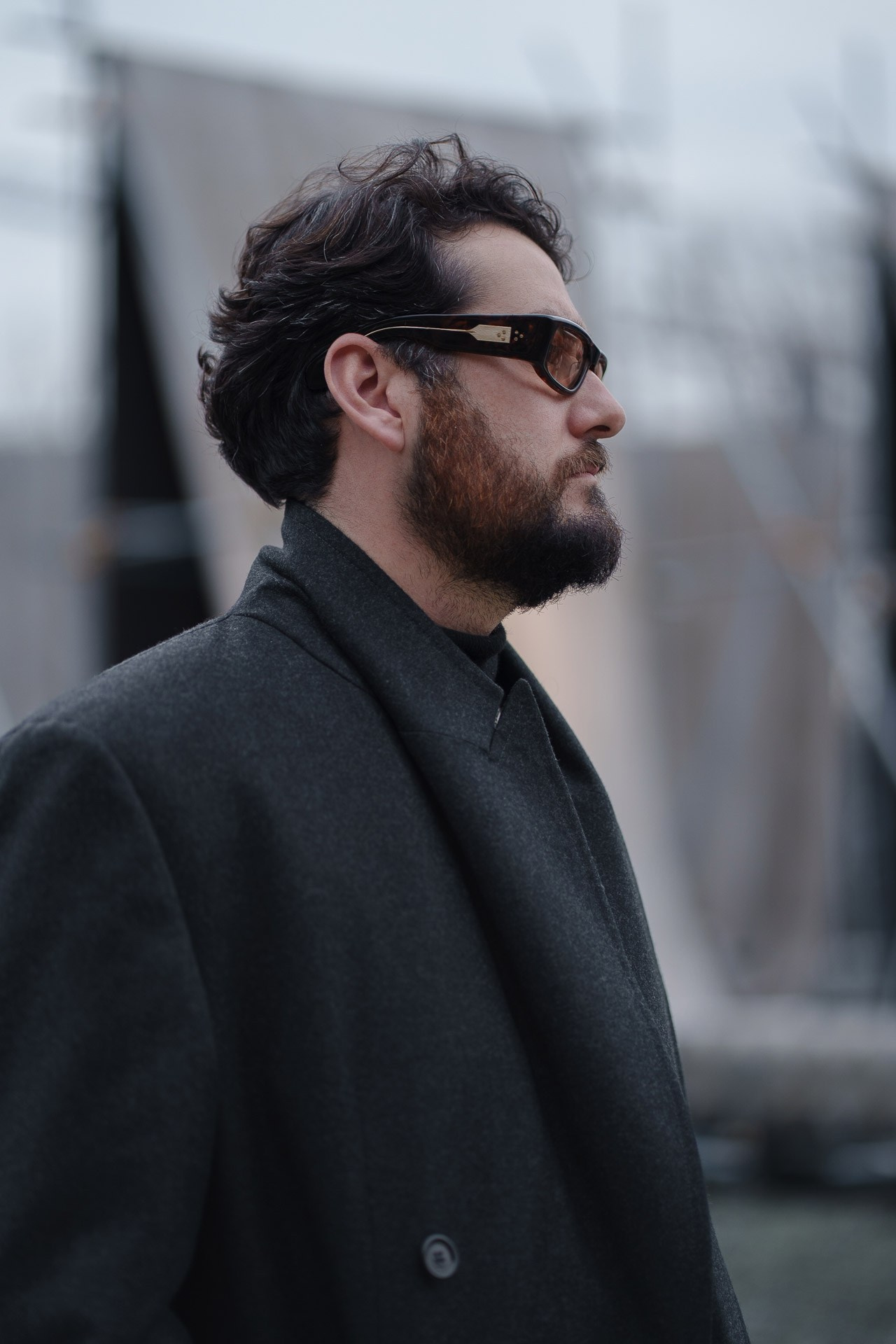 Man in dark coat wearing sunglasses at Pitti Uomo Florence