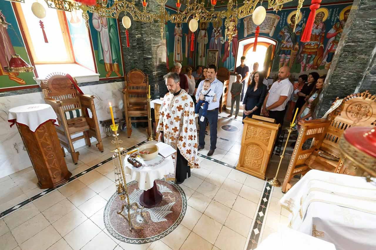 Tradicionalna pravoslavna crkva sa freskama tokom obreda krštenja.