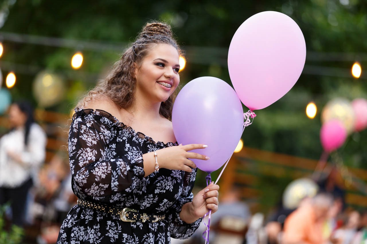 Devojka sa srećnim osmehom na proslavi punoletstva.