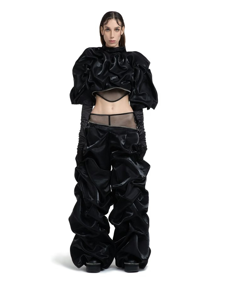 Model in a dramatic black ensemble with sculptural ruffles