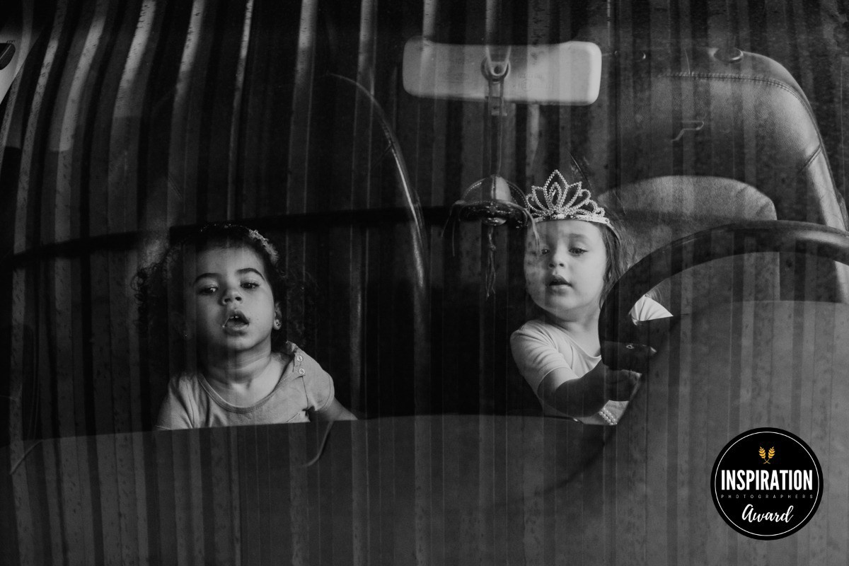 Duas meninas de 2 anos brincando em carro durante ensaio infantil