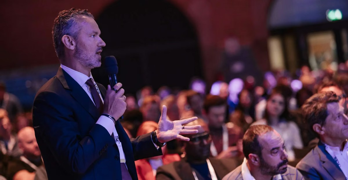 Senior attendee asking a question with a microphone during a conference