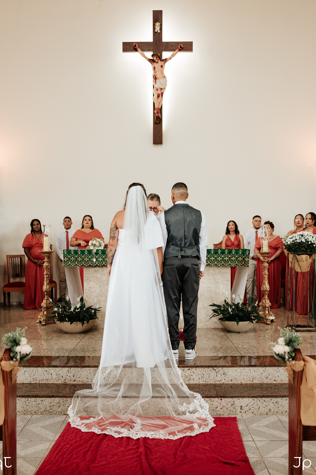 Casal no altar de uma igreja recebendo a benção do padre em Bariri.
