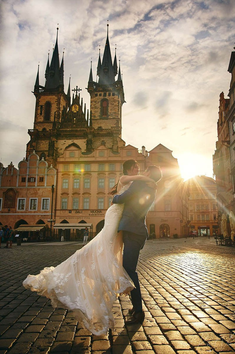 Groom spins bride, Old Town Square, Prague, sunrise
