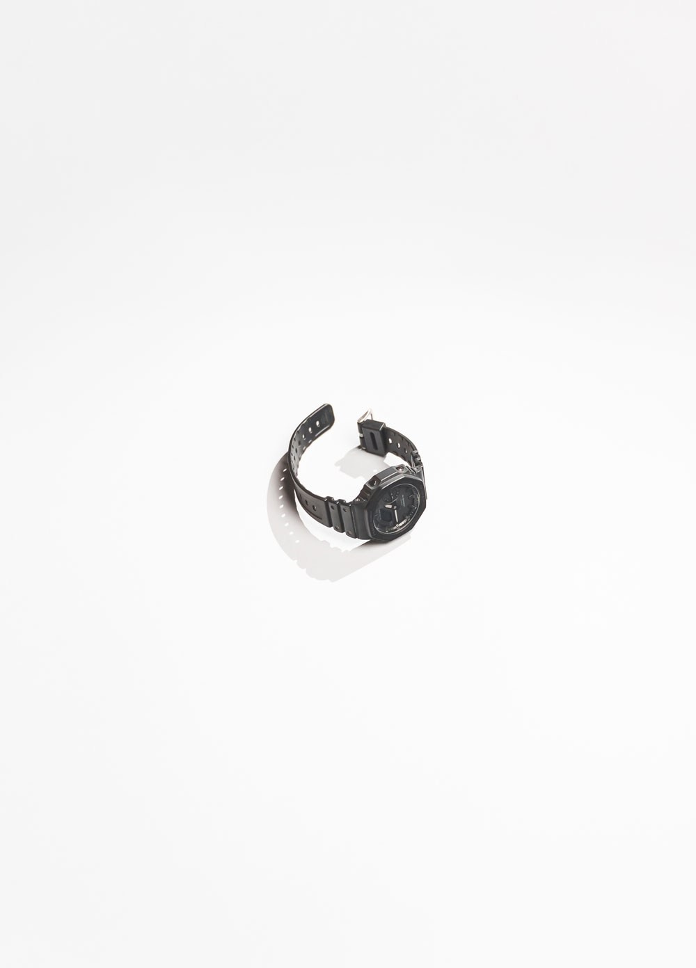 Fotografia de produto minimalista de um relógio em fundo branco com sombra projetada, captada pela empresa de fotografia Khave Media