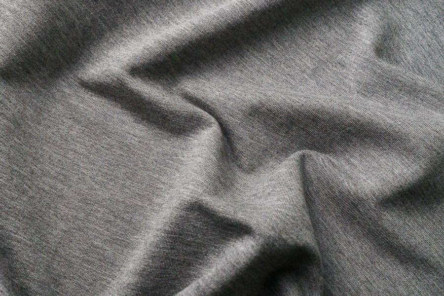 Fotografia de textura e detalhe de tecido cinzento drapeado, captada pela produtora Khave Media