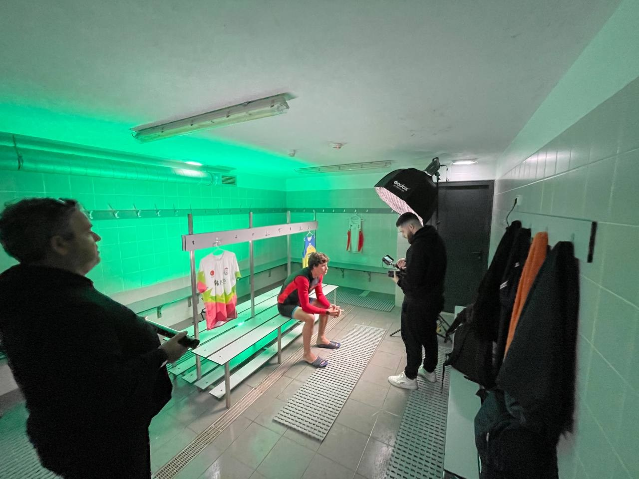 Bastidores de produção audiovisual num balneário desportivo com iluminação verde criativa, captada pela Khave Media