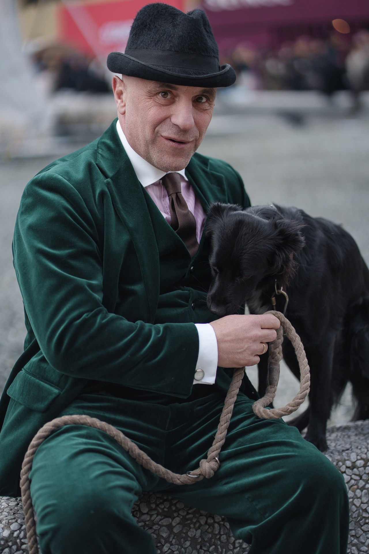 Man in green velvet suit holding dog at Pitti Uomo 109 Florence