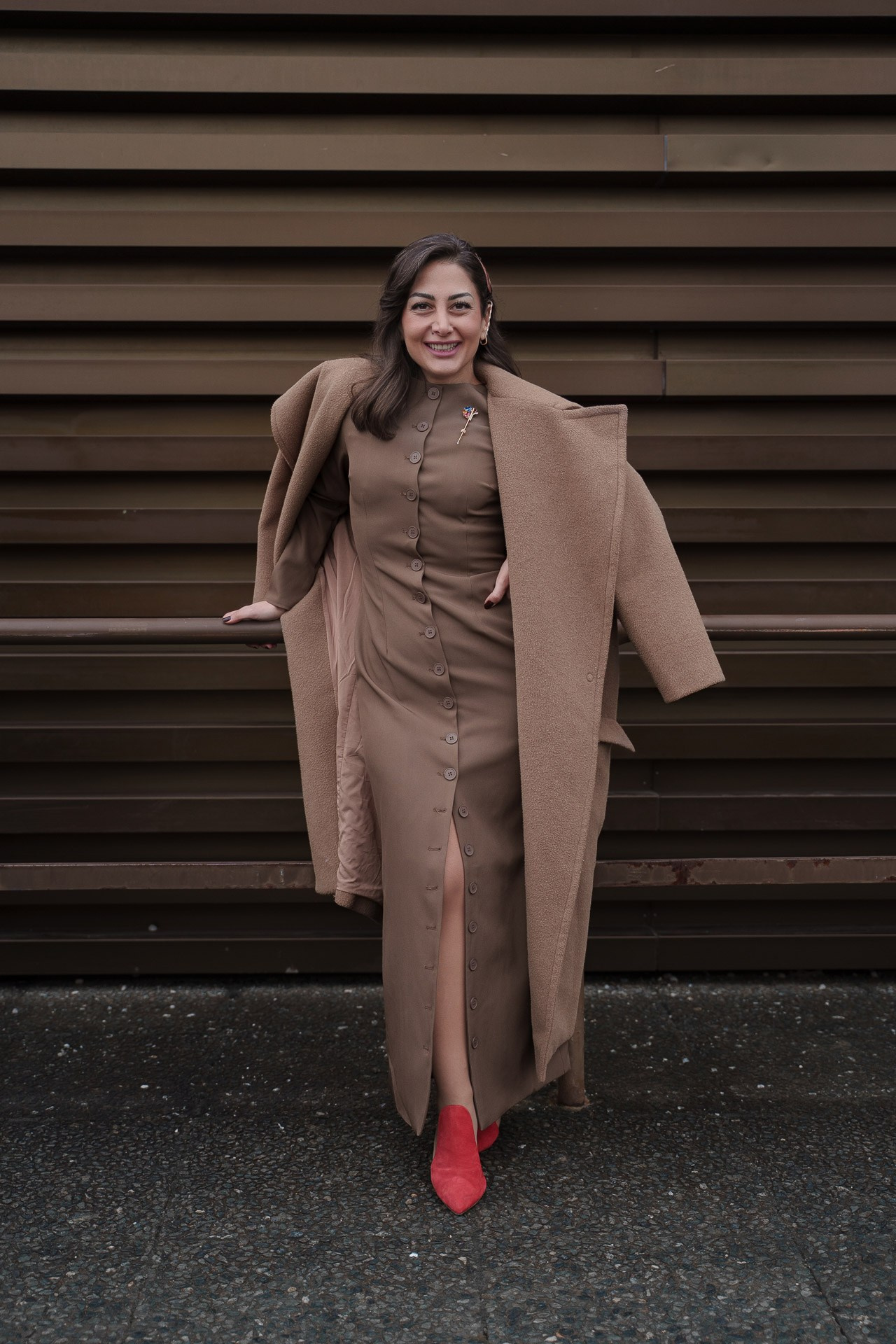 Woman in beige dress and coat with red heels at Pitti Uomo Florence street style