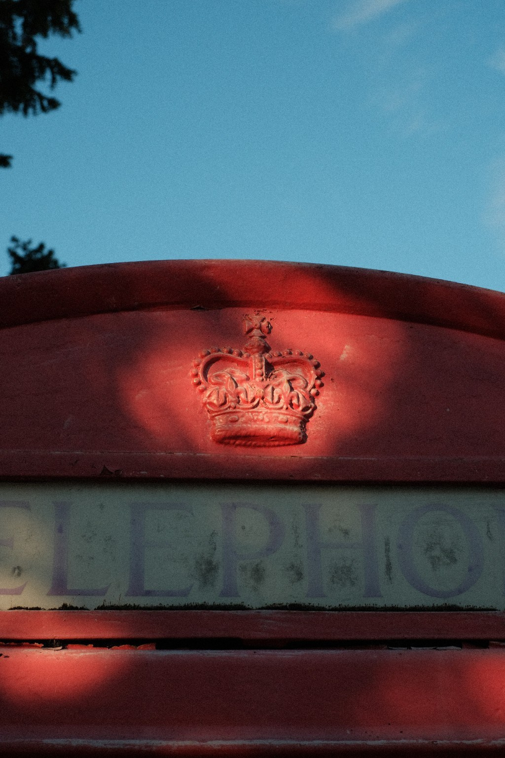 Red post box beneath a blue sky, photographed with a Kodak Gold 200 Fujifilm recipe.