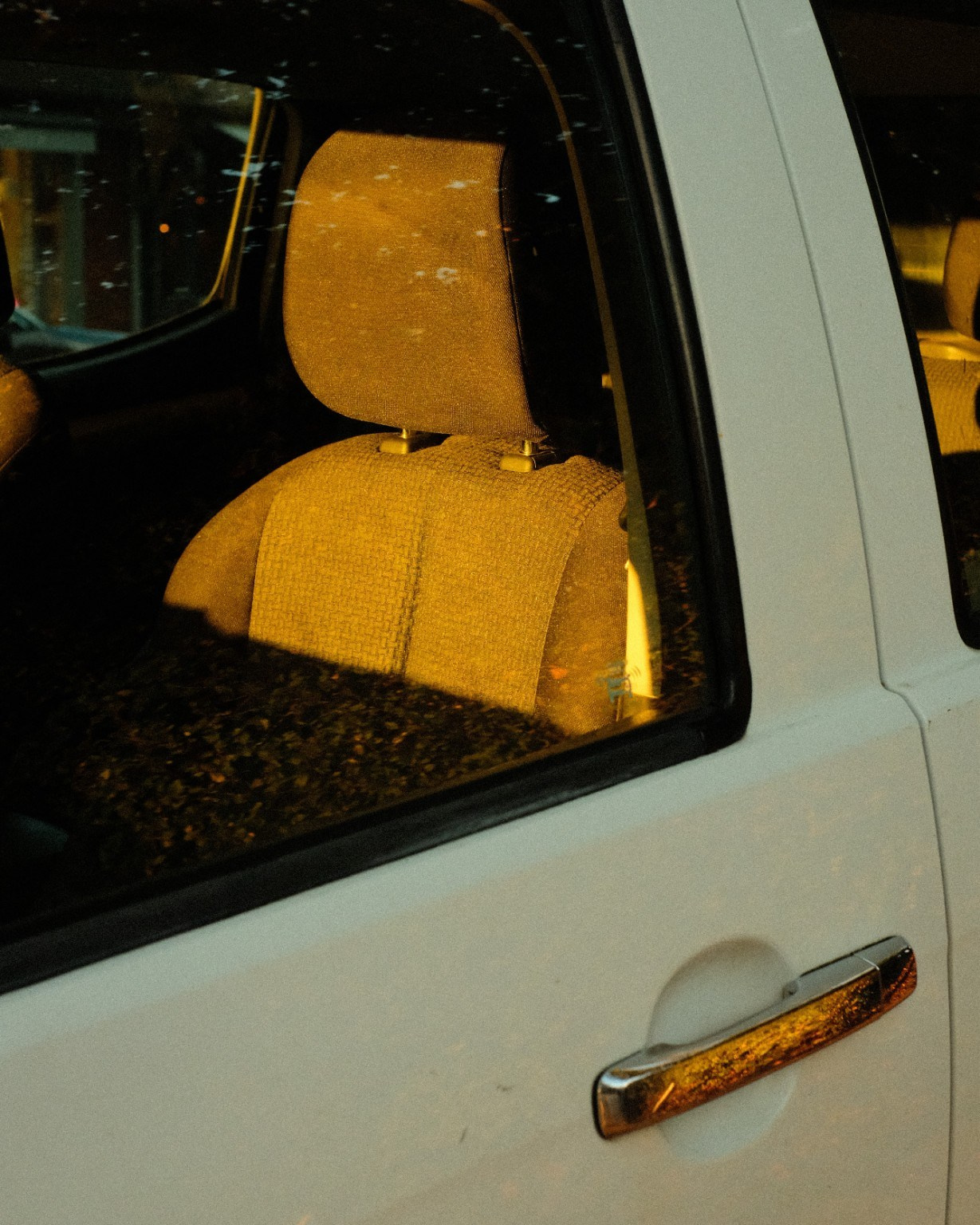 Warm sunlight illuminating a seat inside a white van.