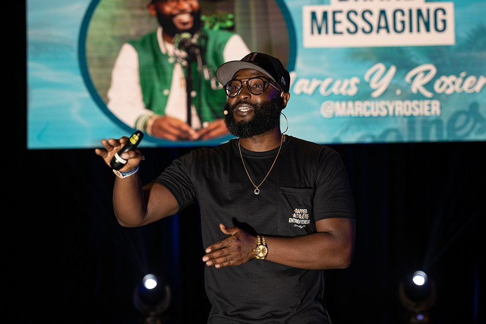 Presenter speaking confidently to room of focused attendees.