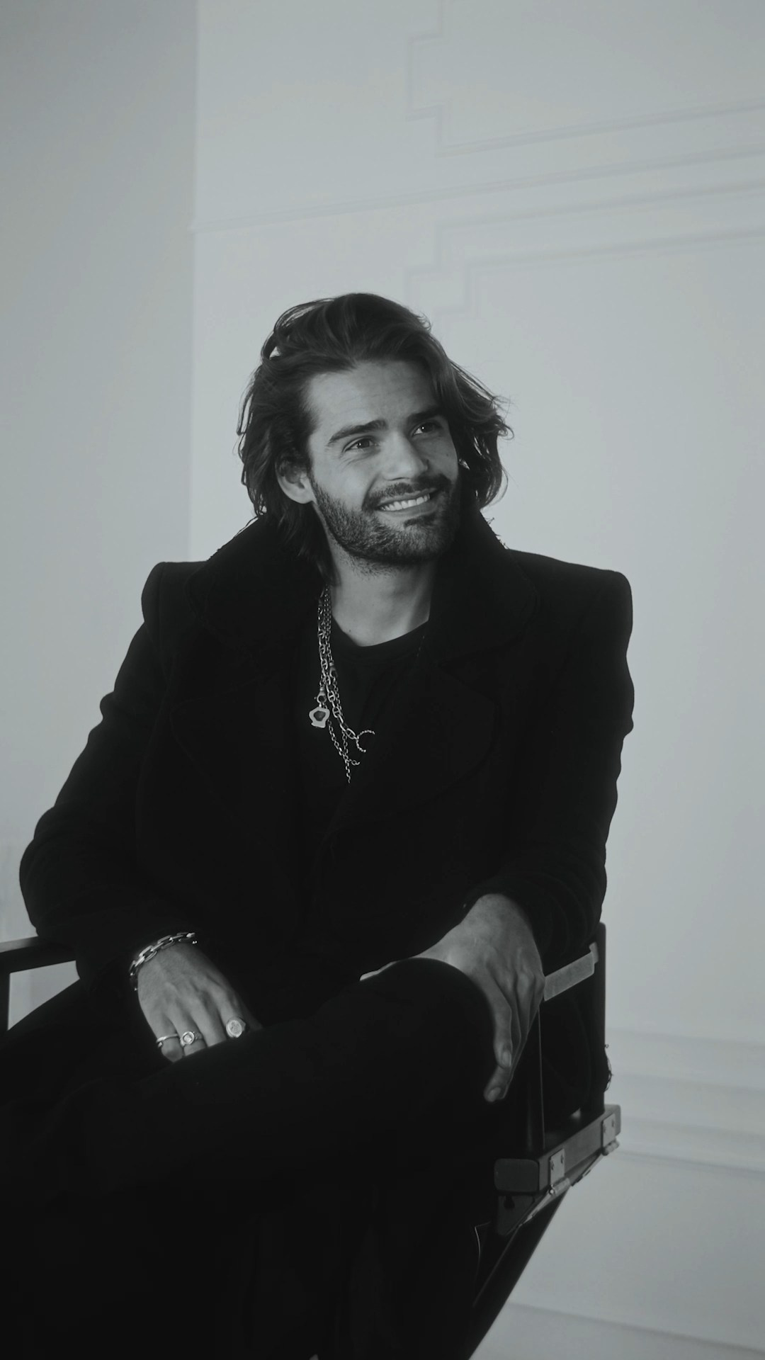 Black-and-white portrait of a male model in a tailored suit, representing timeless elegance in fashion.