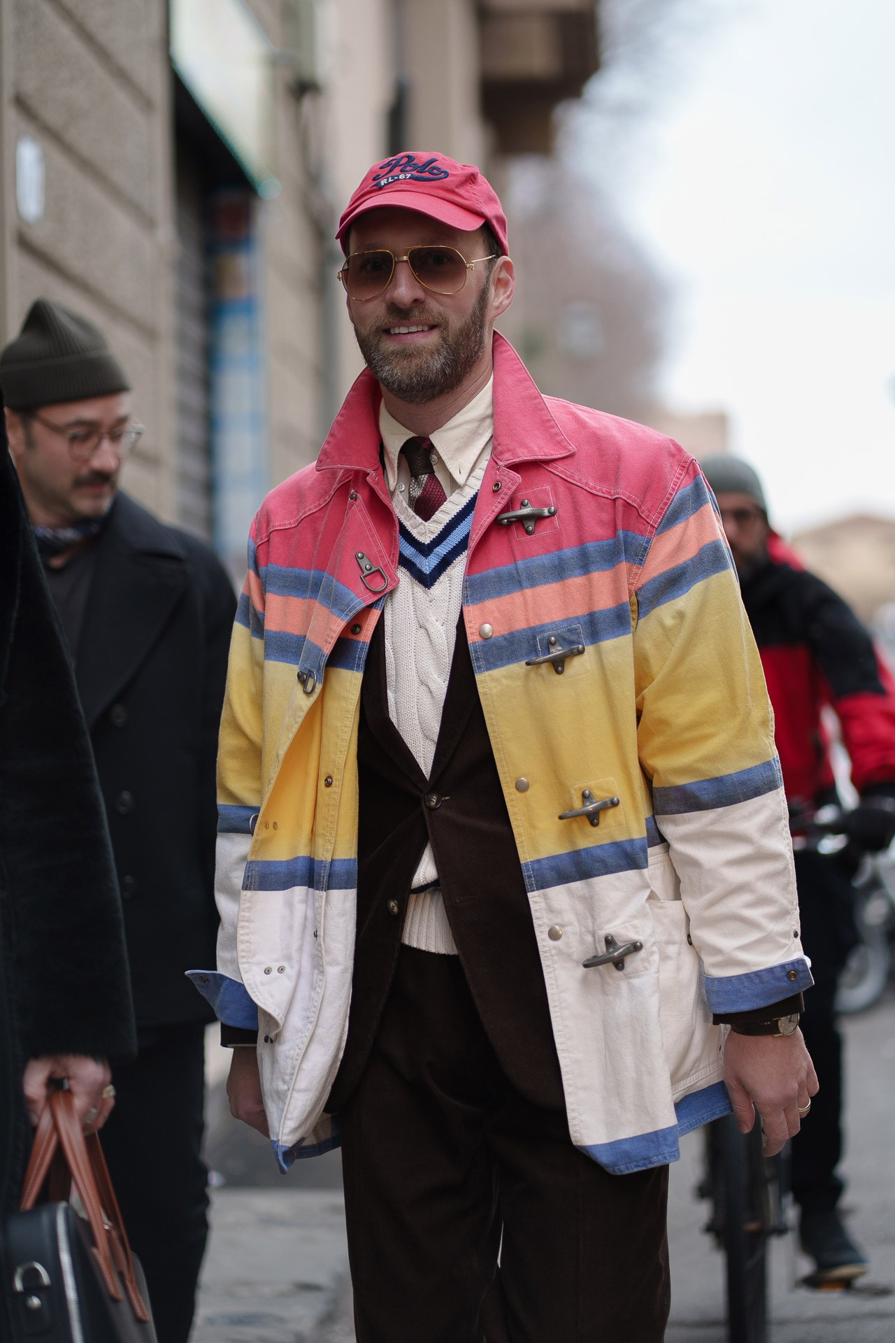 Man in colorful vintage jacket and cap outside Pitti Uomo 109 Florence menswear street style