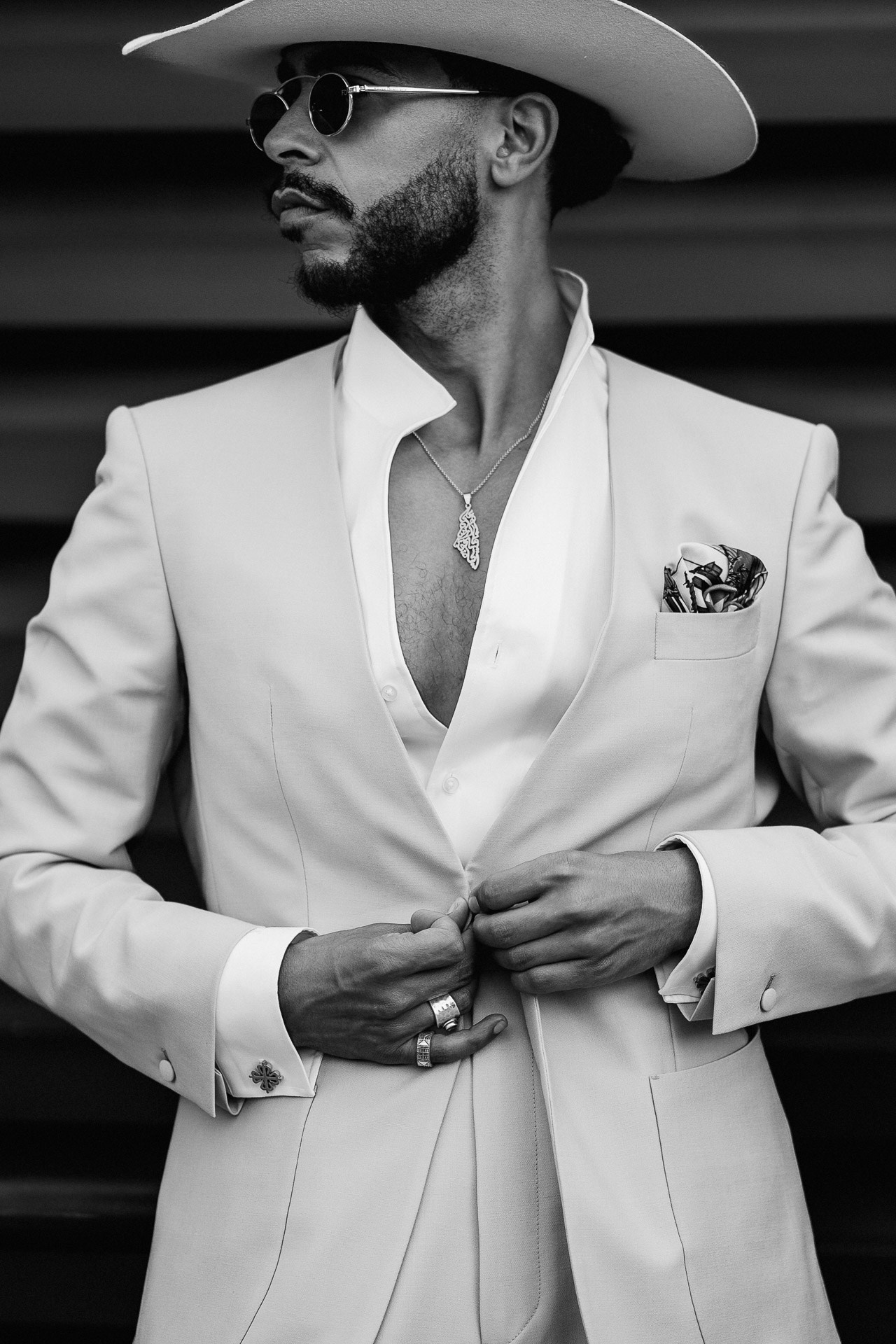 Black and white street style portrait from Pitti Uomo 110, man in white suit and cowboy hat