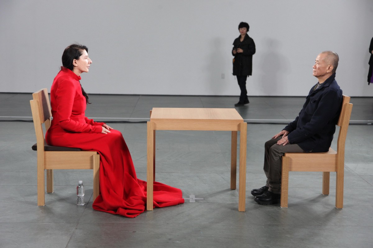 Marina Abramović’s The Artist Is Present (2010) is a landmark performance piece that redefined the boundaries of endurance, presence, and human connection in contemporary art.​ From March 14 to May 31, 2010, at the Museum of Modern Art (MoMA) in New York, Abramović sat silently at a wooden table in the museum's atrium for over 700 hours across 77 days. Visitors were invited to sit across from her, one at a time, engaging in a silent, mutual gaze for as long as they wished. This interaction transformed the traditional artist-viewer relationship into a profound, shared experience.​Abramović described the performance as an exploration of presence, emphasizing the importance of being fully in the moment. She stated, "The performance is really about presence. You have to be in the here and now, 100 percent."