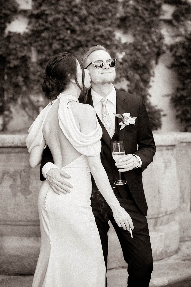 Stylish young couple laughing together in bright afternoon sunlight during their wedding day escape in Prague.