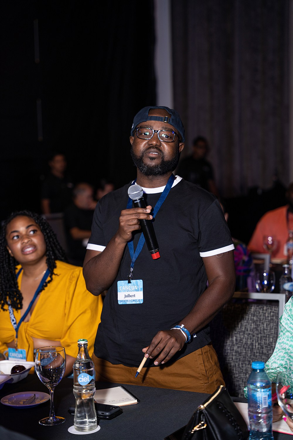 Listener with microphone challenging speaker with thoughtful query.