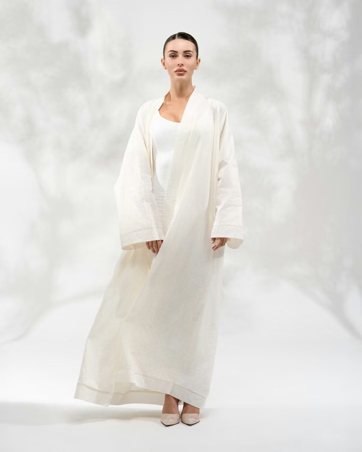 Minimalist studio fashion photography featuring a white abaya with soft lighting
