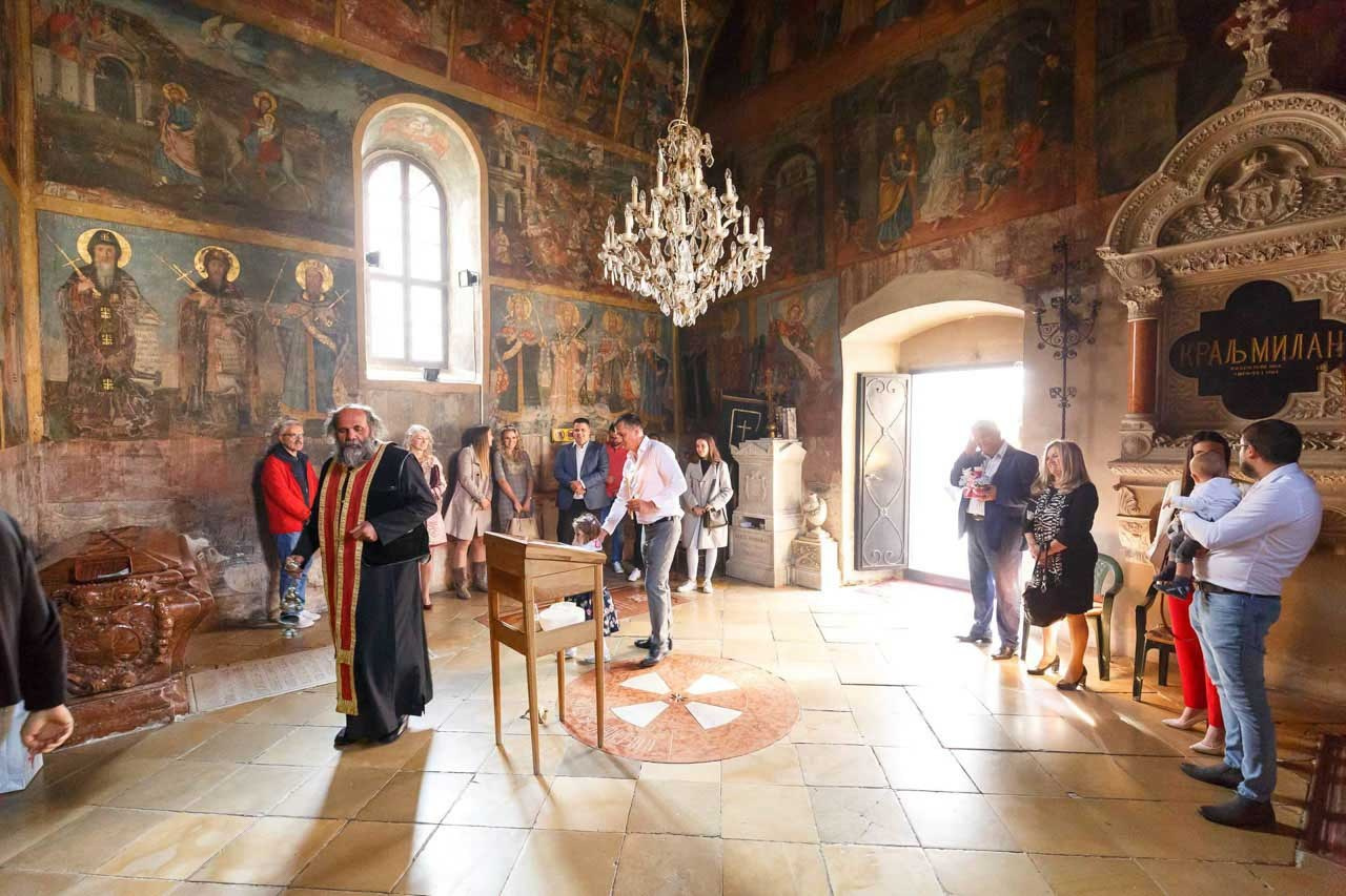 Pravoslavni obred krštenja sa okupljenom porodicom i gostima.