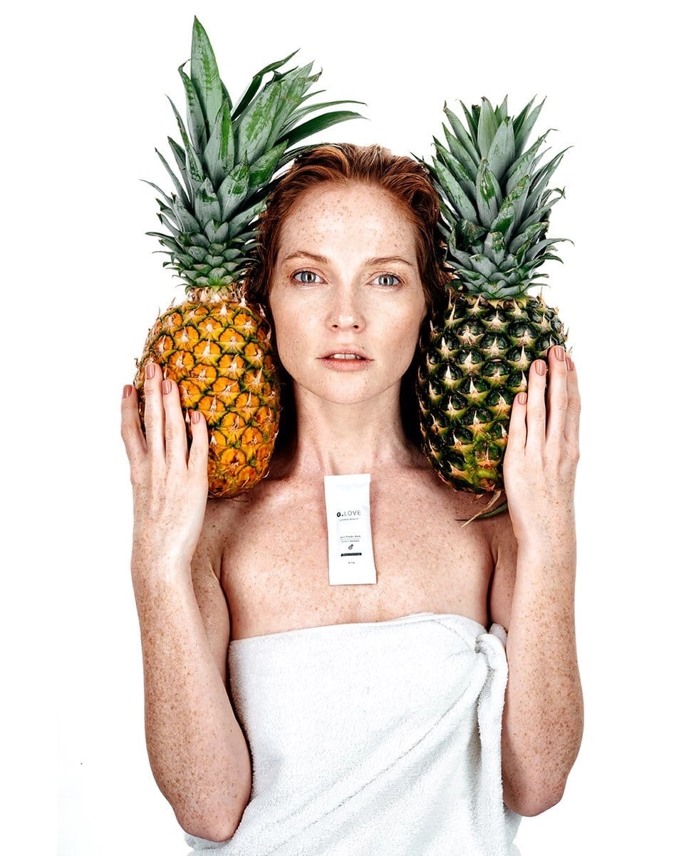 Model posing with her hands on her head, exuding confidence and poise. Her hair is styled in soft waves, and her makeup is subtle yet enhancing. The background is simple, drawing attention to her expressive eyes and the elegance of her pose. This image captures the essence of modern beauty and strength.