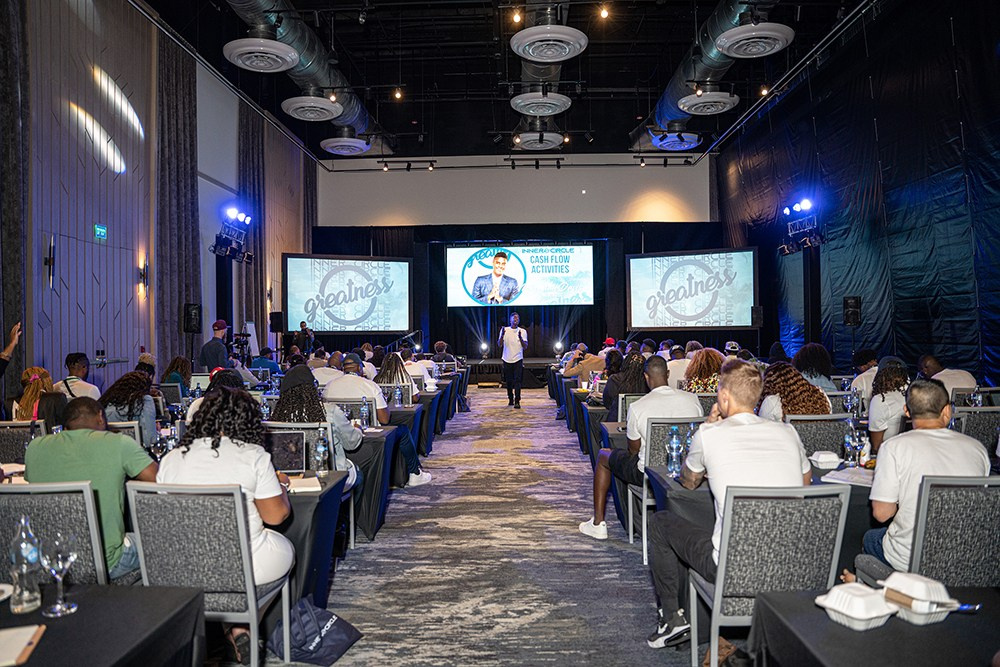 Professional lecturer addressing room of listening participants.