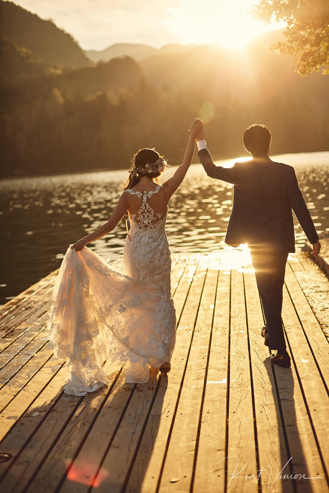 Couple silhouetted dramatic sunset flare pletna dock Lake Bled.