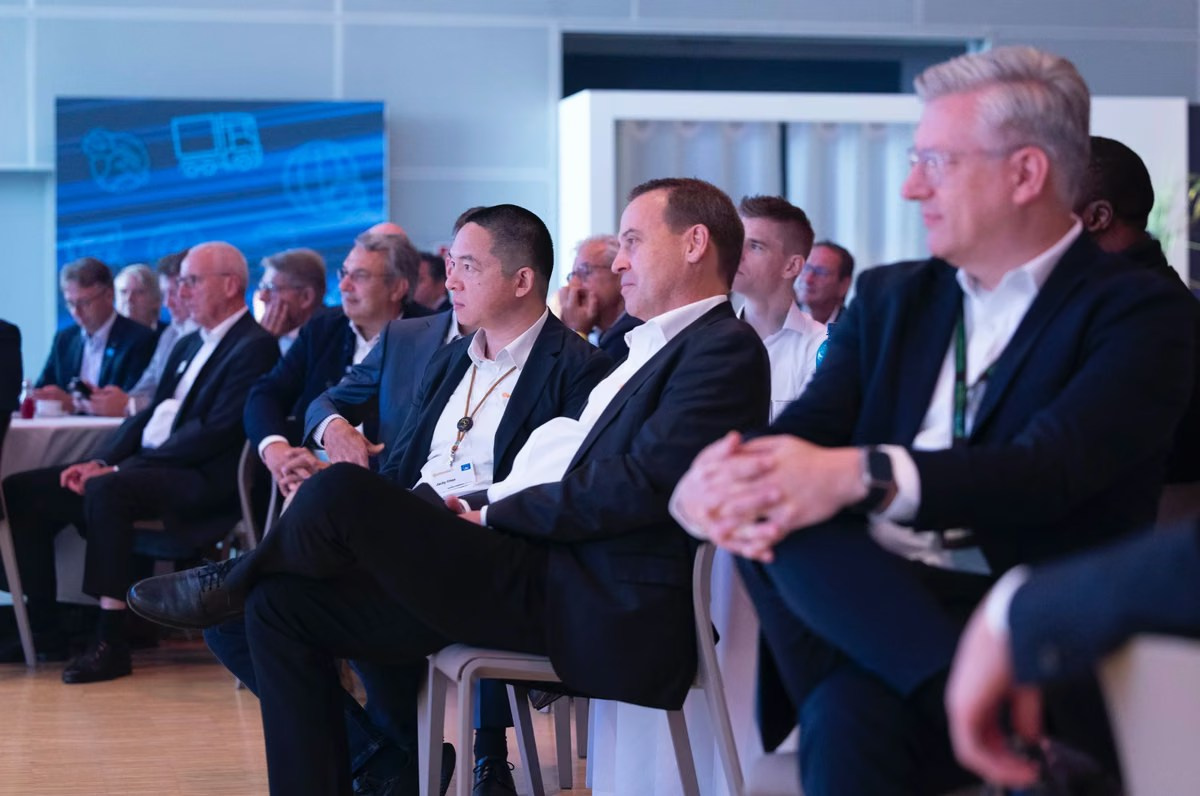 Executives seated on stage during an industry conference panel