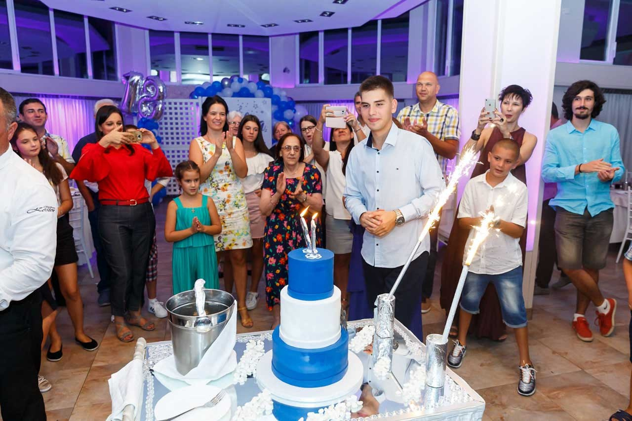 Slavljenik i svečana torta kao centralni deo proslave rođendana.