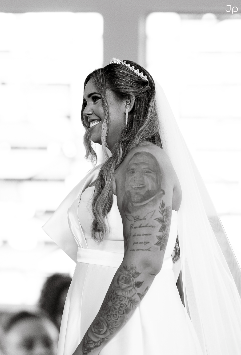 Noiva sorridente com véu esvoaçante e luz suave.